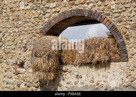 Strohballen hängen auf dem Fensterbrett in einer Scheune auf dem Land Stockfoto