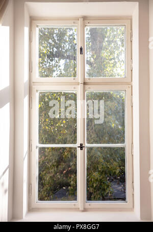 Weiß altmodische Holz- Fenster auf die weiße Wand, grünen Bäumen außerhalb Stockfoto