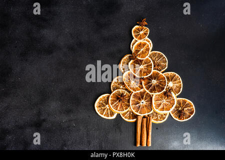 Weihnachten Konzept mit Orangen und Zimt in Weihnachtsbaum auf dunklem Hintergrund geformt Stockfoto