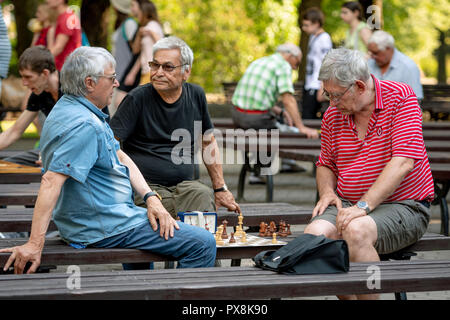 RIGA, Lettland - 18 Juli, 2018: Männer, die auf Parkbänken sitzen und spielen Schach. Stockfoto