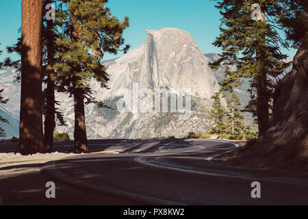 Wunderschöne Aussicht auf Wicklung Glacier Point Road mit berühmten Half Dome Gipfel im goldenen Abendlicht bei Sonnenuntergang, Yosemite National Park, Kalifornien, USA Stockfoto