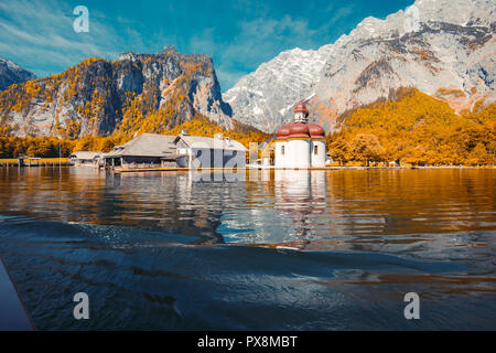 Classic panoramic view of Lake Konigssee with world famous Sankt Bartholomae pilgrimage church and Watzmann mountain on a beautiful sunny day in fall, Stockfoto
