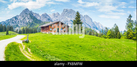 Idyllische Landschaft in den Alpen mit traditionellen Berghütte und frische grüne Almen im Sommer Stockfoto