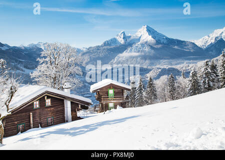 Wunderschöne Aussicht auf traditionellen hölzernen Hütten in der malerischen Winterlandschaft Bergkulisse in den Alpen Stockfoto