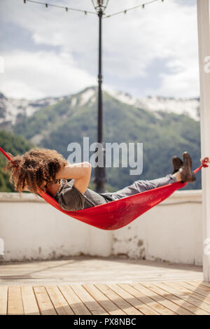 Glückliche Menschen entspannend liegen in der Hängematte auf der Oberseite des Berges. Sommer Urlaub Reisen lifestyle Konzept Stockfoto