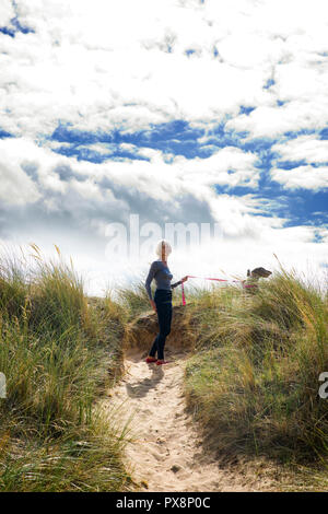 Wandern mit Hund in den Dünen bei Thornham, Norfolk, England Stockfoto