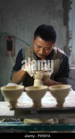 (181020) - JINGDEZHEN, Oktober 20, 2018 (Xinhua) - ein Handwerker namens Zhang Rong macht den zerbrechlichen Körper eines Eierschale Porzellan in Jingdezhen, der ostchinesischen Provinz Jiangxi, am Okt. 19, 2018. Eggshell Porzellan, einer der traditionellen Porzellan in "Chinas Porzellan Kapital" Jingdezhen hergestellt, verfügt über einen Papery und durchsichtigen Porzellan Körper. Mit zehntausenden von komplizierten rein handgemachte Herstellung Schritte, jeder einzelne Eierschale Porzellan muss mindestens zwei Monaten verbraucht. (Xinhua/Hu) (sxk Chenhuan) Stockfoto