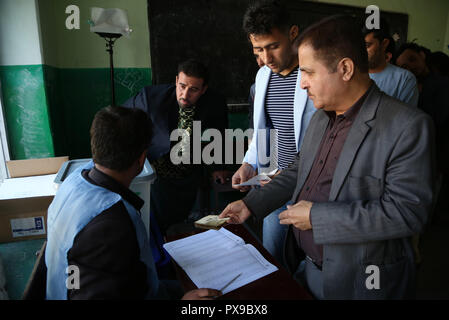 (181020) - KABUL, Oktober 20, 2018 (Xinhua) - ein afghanischer Unabhängige Wahlkommission (IEC) Arbeiter registriert ein Wähler im Wahllokal während der Parlamentswahlen in Kabul, Afghanistan, am Okt. 20, 2018. Millionen afghanischer Votierten am Samstag für lange verzögerte Parlamentswahlen in der militanz - gequälte Land unter Reports der Sicherheitsbedrohungen und Unregelmäßigkeiten. (Xinhua / Rahmat Alizadah) Stockfoto