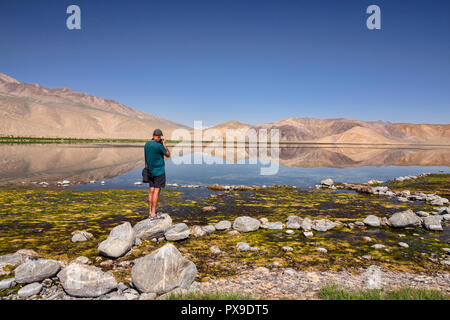 Fotograf schießt Foto von Berg Reflexionen in schönen Bulunkul See, Obere Gunt Tal, Pamir, Gorno Badkhshan, Tadschikistan Stockfoto