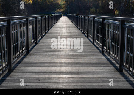 Eine Brücke aus Planken in Mitteleuropa. Überquerung des Flusses auf einem Gitter von der Schmalspurbahn Brücke gebaut. Jahreszeit der Herbst. Stockfoto