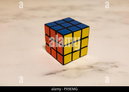 Rubik's Cube auf einer Marmorplatte, Blau, Gelb und Rot closeup Stockfoto