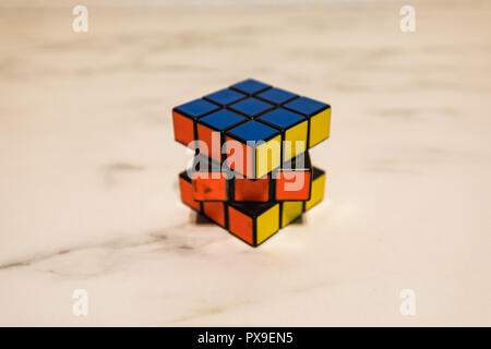 Rubik's Cube auf einer Marmorplatte, Blau, Gelb und Orange closeup Stockfoto
