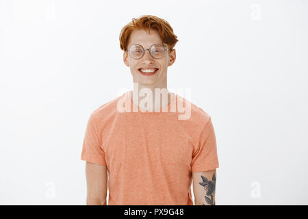 Freut mich. Smart attraktive rothaarige Menschen mit Sommersprossen und Tätowierungen, lächelnd mit freundlich und froh, Ausdruck, neue Leute treffen bei der Arbeit Stockfoto