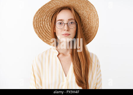 Attraktive stilvolle hipster Mädchen mit Ingwer Haar und Sommersprossen in modischen Brille Strohhut und gelbe süße Bluse lächelnd mit Ihnen unbeschwerten Ausdruck Teilnahme an interessanten Vortrag im Cafe Stockfoto