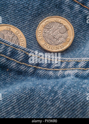 Neue Pound Münze und Hosentasche. Metapher für "das Pfund in der Tasche' oder Tasche änderung, UK Löhne Konzept, Pfund Sterling, letzten Pfund in der Tasche. Stockfoto