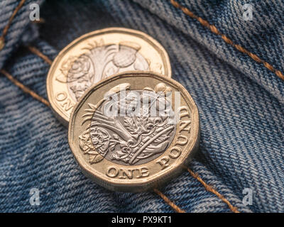 Neue Pound Münze und Hosentasche. Metapher für "das Pfund in der Tasche' oder Tasche änderung, UK Löhne Konzept, Pfund Sterling, letzten Pfund in der Tasche. Stockfoto