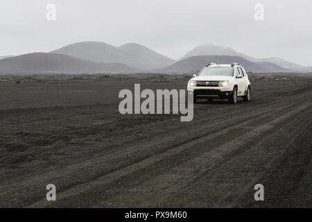 LANDMANNALAUGAR, ISLAND - AUGUST 2018: Auto fahren auf der schwarzen Lava Feld auf dem Weg nach Landmannalaugar, Island. Stockfoto