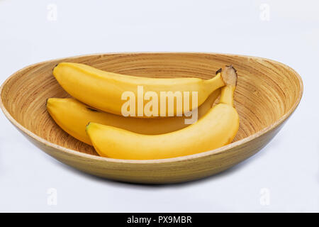 Frische Bananen in einer Schüssel auf weißem Hintergrund Stockfoto