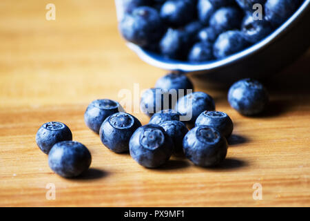 Heidelbeeren in eine Schüssel auf hölzernen Tisch Stockfoto