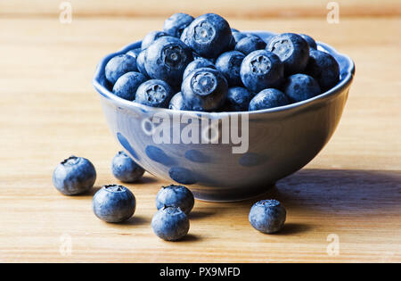 Heidelbeeren in eine Schüssel auf hölzernen Tisch Stockfoto