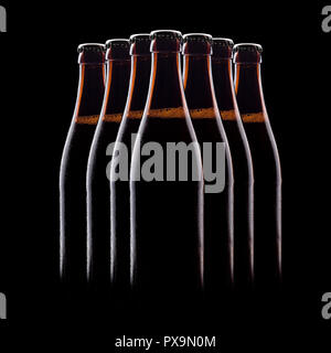 Gruppe von braunen Flasche Bier, auf einem schwarzen Hintergrund, mit leuchtenden Kanten und Schaum Stockfoto