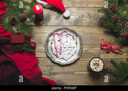 Weihnachten Zusammensetzung der Kranz, pleid, Tasse Kaffee auf Holzbrett. Flach. Ansicht von oben. Bar Schokolade. Stockfoto