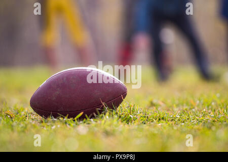 Pro American Football auf dem Feld mit grünem Gras Spieler im Hintergrund Stockfoto