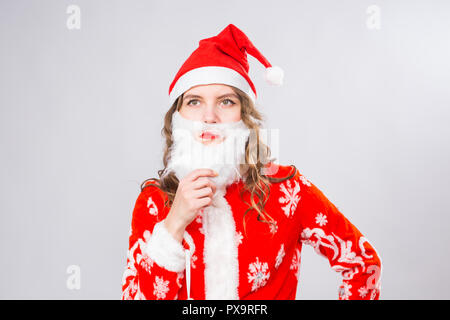 Weihnachten, Emotionen und Witz Begriff - Frau in Santa Kostüm mit falschen Bart betrachten sie ernst und wütend auf weißem Hintergrund mit Kopie Raum Stockfoto