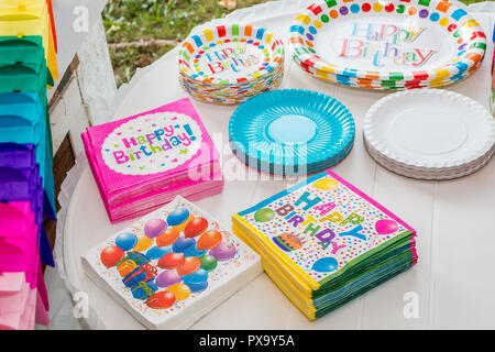 Weißer Tisch serviert mit Einweggeschirr, bunte Servietten, Pappteller, für die Party bereit. Close Up. Stockfoto