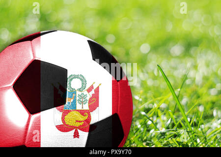 Fußball auf Gras mit Flagge von Peru malte auf es Stockfoto