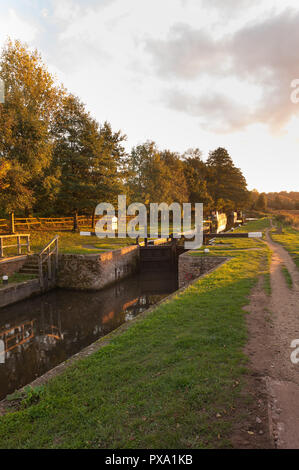 Catteshall Lock auf dem Fluss Wey, Godalming, bei Sonnenuntergang auf einem schönen Sommer Abend, mit ruhigen Kanal Wasser Stockfoto