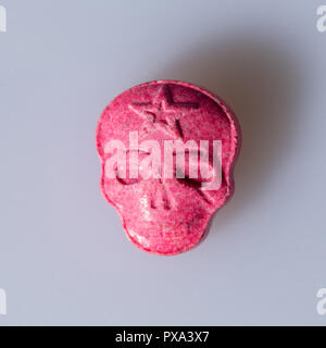 Eine Rote Armee Schädel, Ecstasy, MDMA oder Medikamente Pille wie ein Schädel auf grauem Hintergrund geprägt. Stockfoto