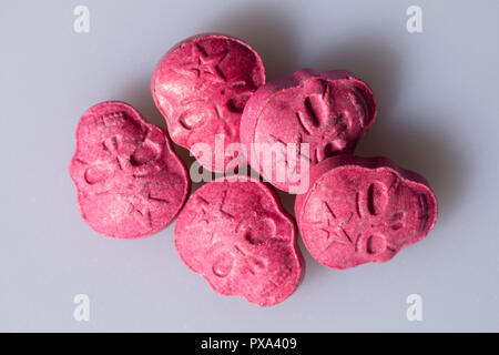 Fünf rote Armee Schädel, Ecstasy, MDMA oder Medikamente wie ein Schädel auf grauem Hintergrund geprägt. Stockfoto