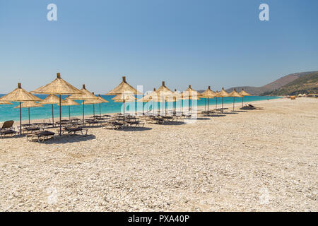 Sonnenschirme am Strand Borsh in Albanien. Steiniger Strand an der Adria. Stockfoto