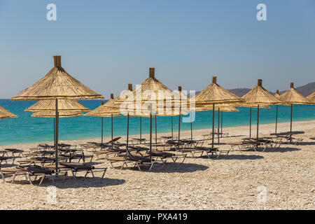 Sonnenschirme am Strand Borsh in Albanien. Steiniger Strand an der Adria. Stockfoto