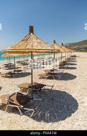 Sonnenschirme am Strand Borsh in Albanien. Steiniger Strand an der Adria. Stockfoto