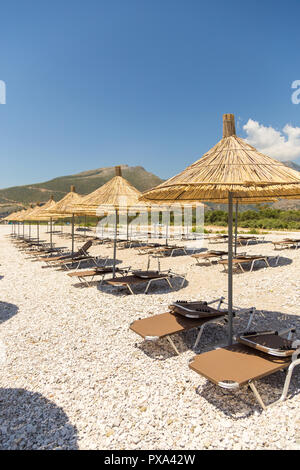 Sonnenschirme am Strand Borsh in Albanien. Steiniger Strand an der Adria. Stockfoto