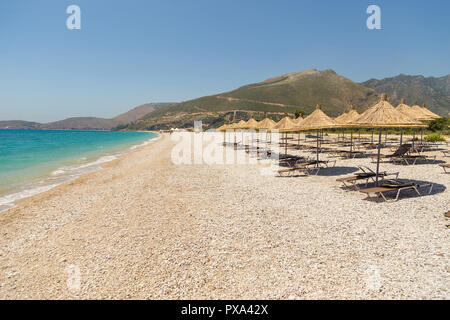 Sonnenschirme am Strand Borsh in Albanien. Steiniger Strand an der Adria. Stockfoto