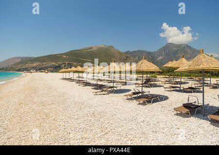 Sonnenschirme am Strand Borsh in Albanien. Steiniger Strand an der Adria. Stockfoto