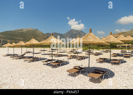 Sonnenschirme am Strand Borsh in Albanien. Steiniger Strand an der Adria. Stockfoto