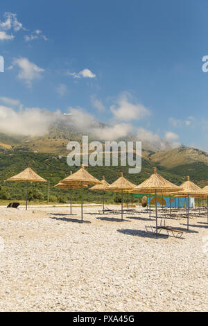 Sonnenschirme am Strand Borsh in Albanien. Steiniger Strand an der Adria. Stockfoto