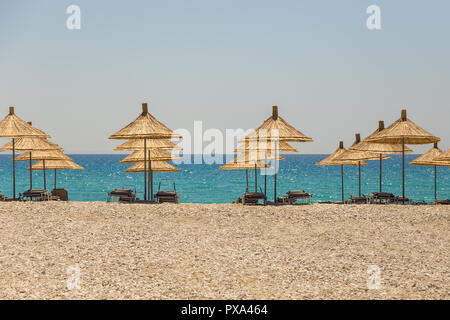 Sonnenschirme am Strand Borsh in Albanien. Steiniger Strand an der Adria. Stockfoto