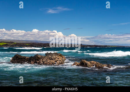 Bucht am schwarzen Sandstrand (punaluu), auf der grossen Insel von Hawaii. Weiße Wellen auf dem blauen Pazifischen Ozean. Stockfoto