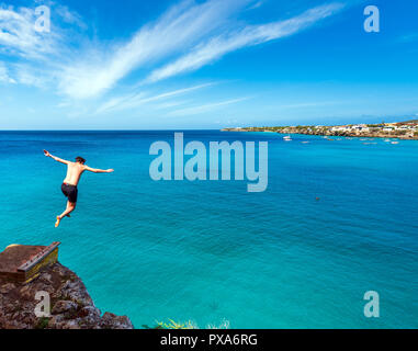 Mann weg von einer Klippe zu springen, Westpunt, Curacao, Niederlande. Kopieren Sie Platz für Text Stockfoto