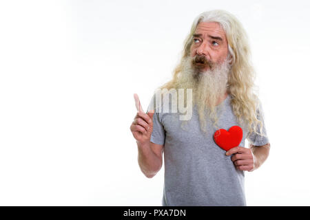 Studio shot der älteren bärtigen Mann mit roten Herzen während thinki Stockfoto