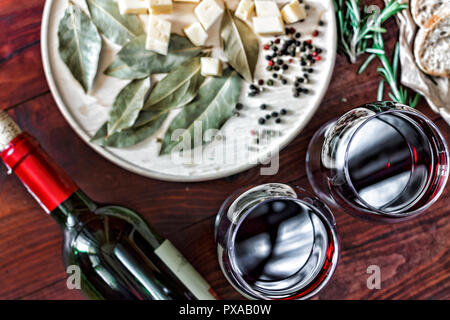 Rotwein im Glas auf einem Tisch, Käse Snacks. Brot, Ansicht von oben Stockfoto