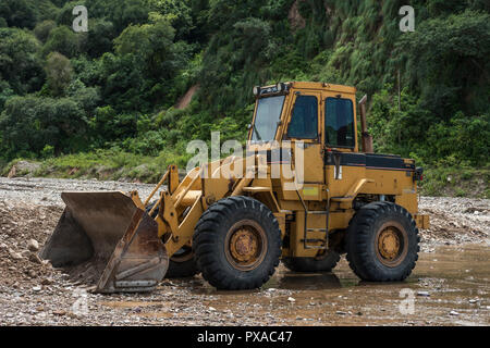 Gelben bulldozer nimmt einen Bruch am Ufer des Flusses Stockfoto