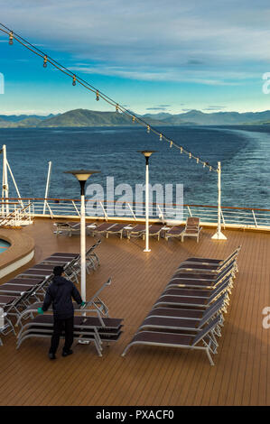 Inside Passage, BC, Kanada - 13 September, 2018: Kreuzfahrtschiff Arbeiter an Bord der Volendam, Stapeln Lounge im Freien Stühle in der Nähe des Endes der Tag der Stockfoto