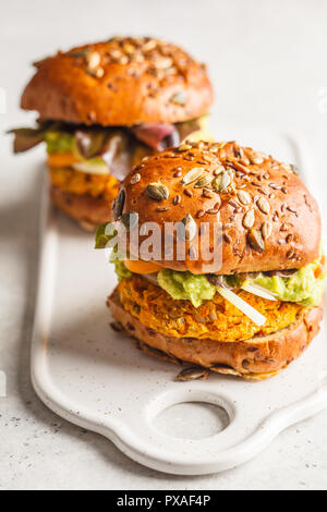 Vegan Kürbis Burger auf weißen Hintergrund. Pflanzlichen Burger, Avocado, Gemüse und Brötchen. Stockfoto