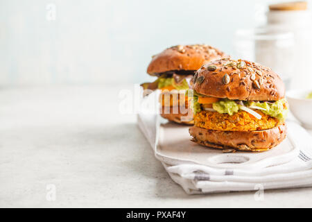 Vegane Kartoffel (oder Kürbis) Burger auf weißen Hintergrund. Pflanzlichen Burger, Avocado, Gemüse und Brötchen. Sauber Essen, pflanzliche Nahrung Konzept. Stockfoto